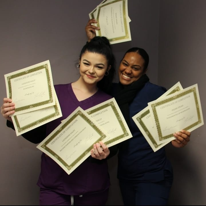 two women with certificates in their hands
